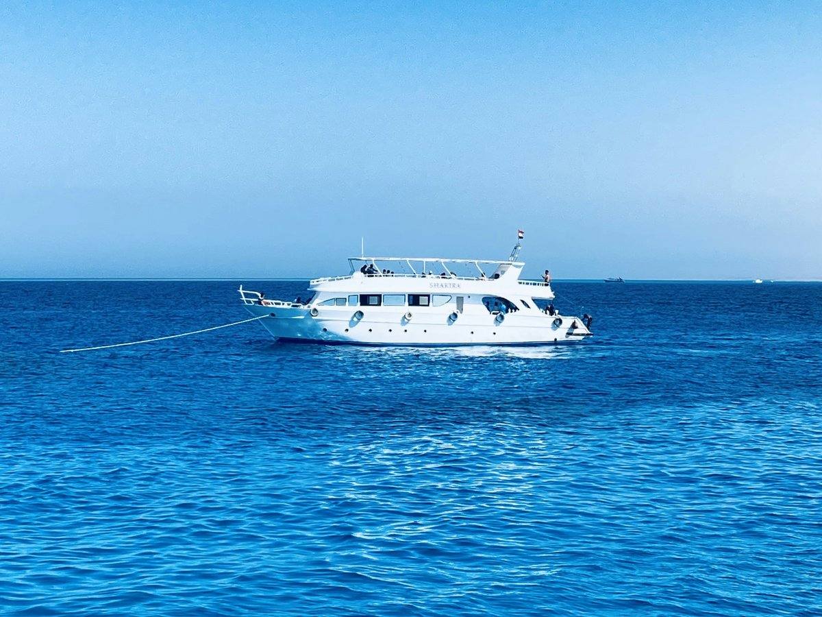 Weißes Ausflugsboot liegt vor Anker auf dem tiefblauen Roten Meer bei Hurghada