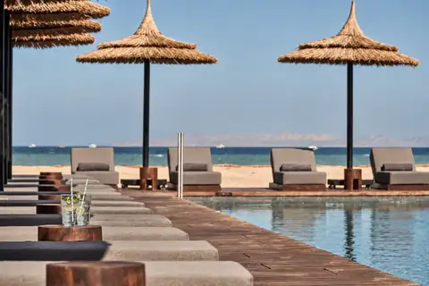 KI-Illustration: Poolterrasse mit Liegen und Meerblick im Casa Cook El Gouna