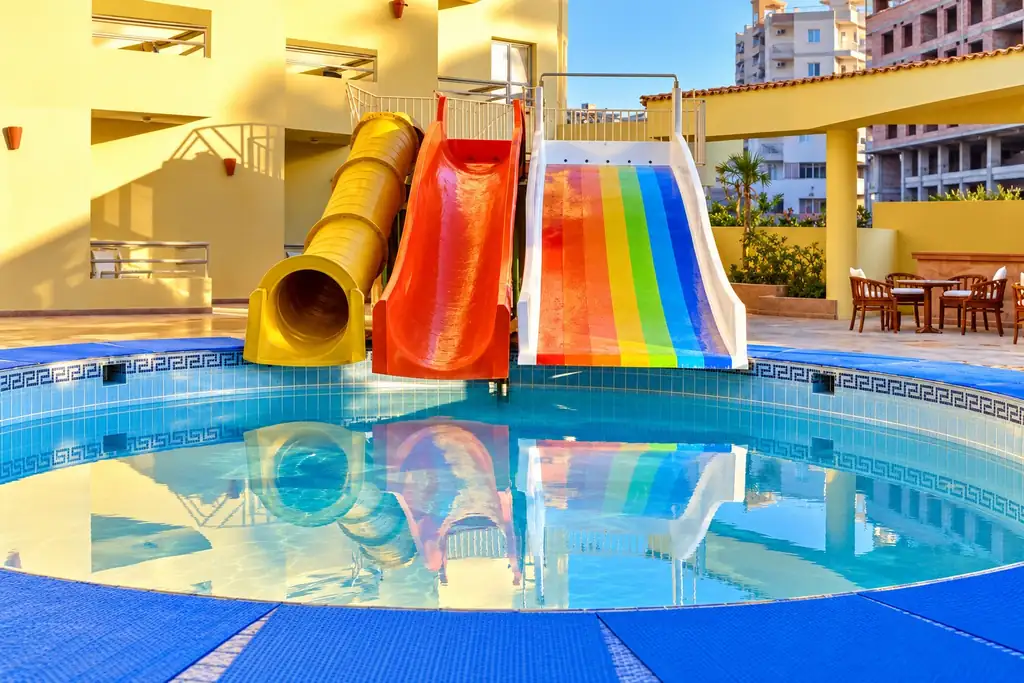 KI-Illustration: Kinderpool mit Rutschen im Dexon Roma Hotel