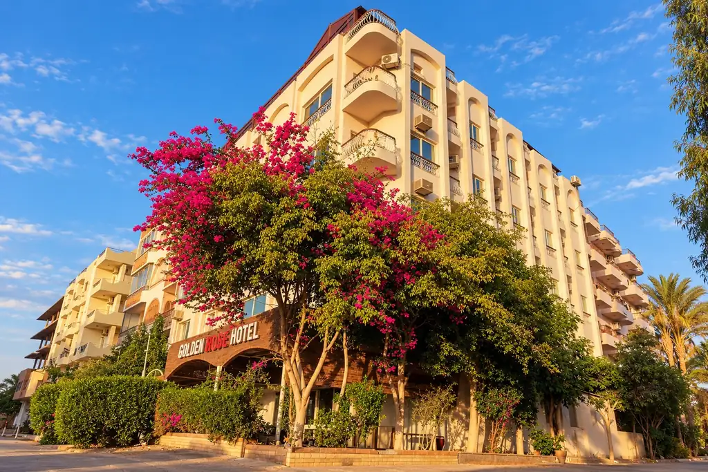 KI-Illustration: Hotelfassade mit Garten im Golden Rose Hotel