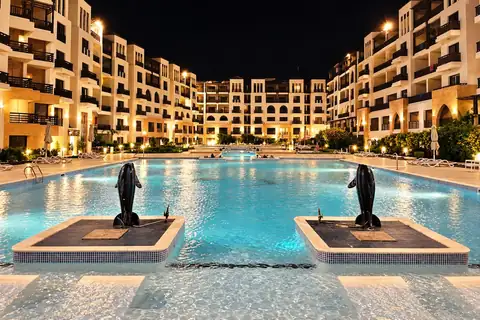KI-Illustration: Beleuchteter Poolhof bei Nacht im Gravity Hotel & Aqua Park Hurghada