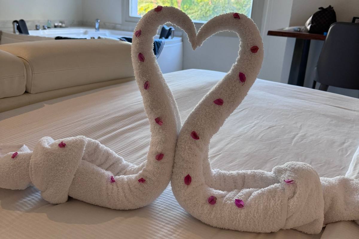 Zwei Handtuchschwäne mit Herz auf einem frisch gemachten Hotelbett in Hurghada