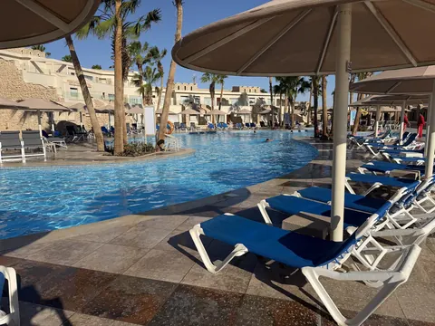 Hotelpool mit blauen Liegen und Sonnenschirmen am frühen Morgen im Pickalbatros Citadel in Sahl Hasheesh