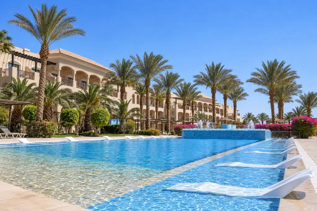 KI-Illustration: Pool mit Wasserliegen und Hotelgebäuden im JAZ Aquamarine