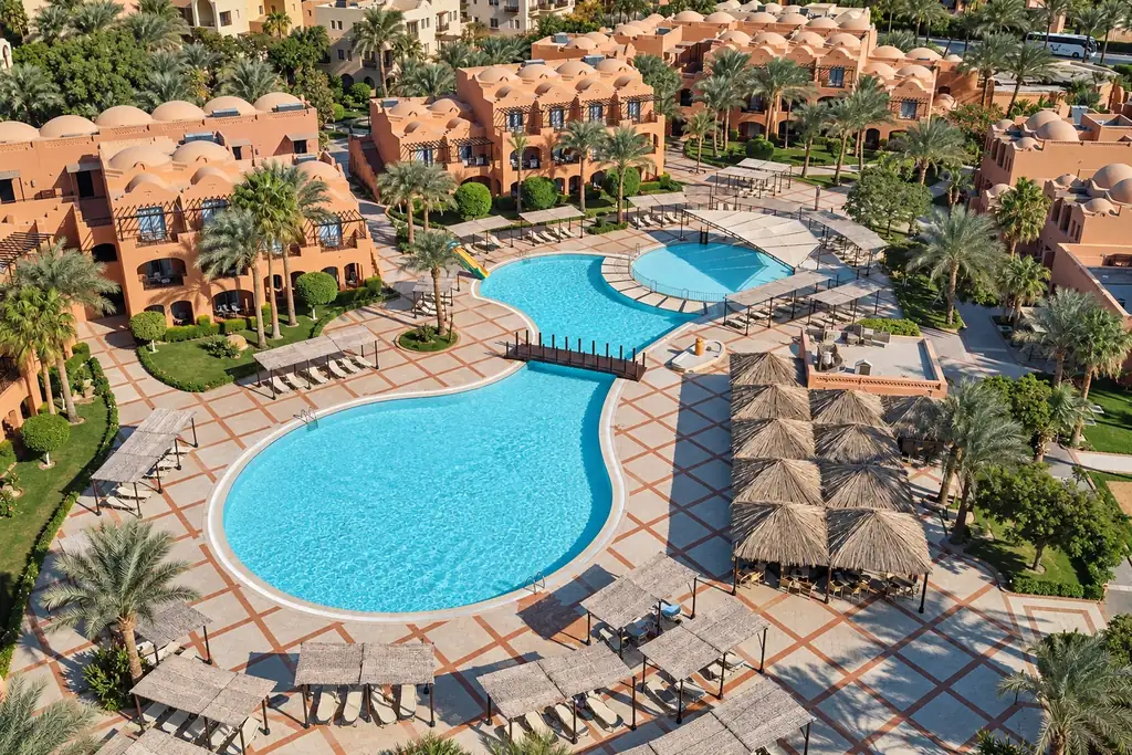 KI-Illustration: Poolhof und terrakottafarbene Hotelgebäude im JAZ Makadi Oasis Resort