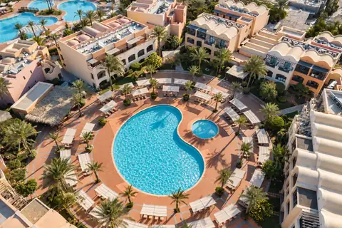 KI-Illustration: Poolhof zwischen Hotelgebäuden aus der Luft im JAZ Makadi Saraya Resort