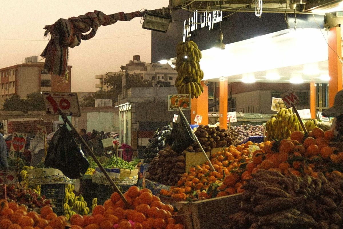 Marktstand mit Orangen, Bananen und Preisschildern in Ägyptischen Pfund am Abend