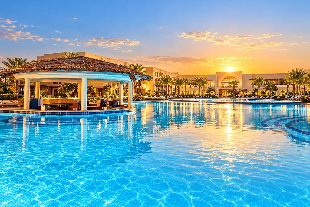 KI-Illustration: Pool mit Poolbar bei Sonnenuntergang im Mövenpick Waterpark Resort & Spa Soma Bay