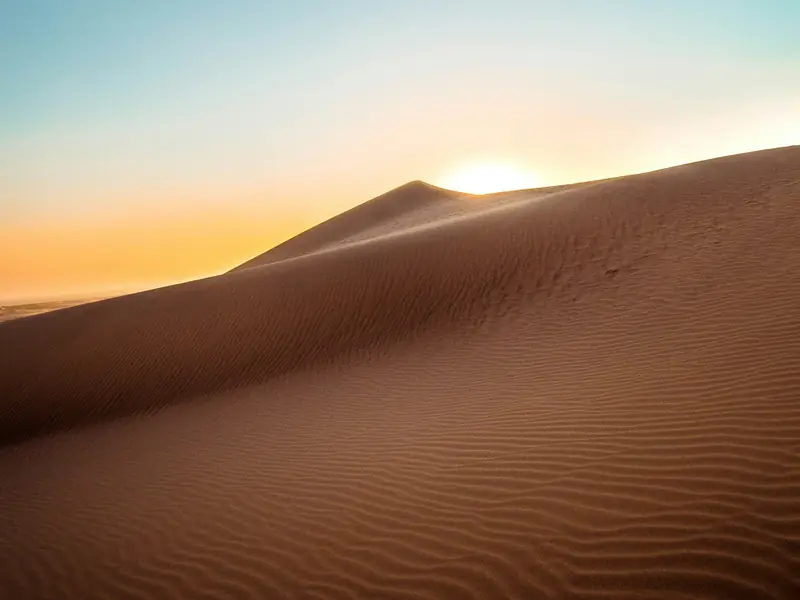 Sanddüne mit feinem Wellenmuster bei Sonnenaufgang
