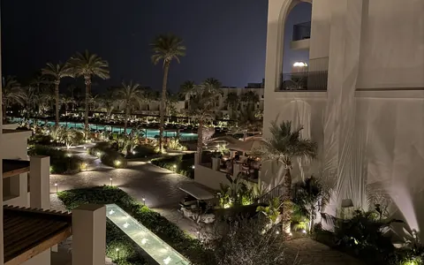 Beleuchtete Gartenwege, Palmen und Pools im Serry Beach Resort in Hurghada am Abend
