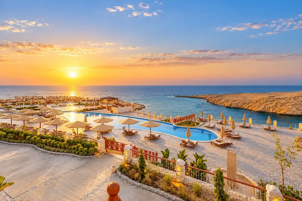 KI-Illustration: Pool und Strand bei Sonnenuntergang im Siva Golden Bay Makadi