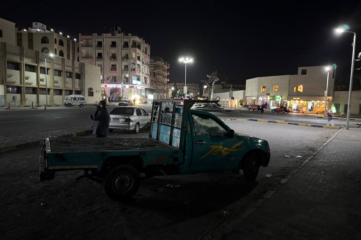 Straße in El Dahar am Abend mit Pick-up, Straßenlaternen und beleuchteten Geschäften