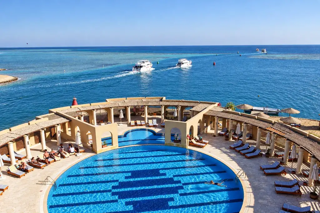KI-Illustration: Runder Pool mit Meerblick im Three Corners Ocean View